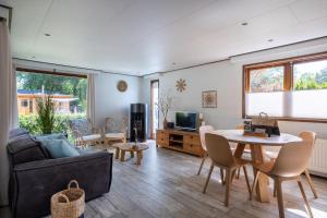 a living room with a couch and a table at Bungalowpark Het Verscholen Dorp in Harderwijk