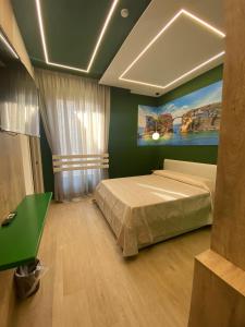 ナポリにあるRelais Piazza Del Plebiscito B&Bの緑の壁、ベッド付きのベッドルーム1室