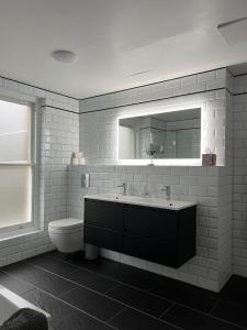 uma casa de banho com um lavatório, um WC e um espelho. em Luxury Apartment in Belsize Park em Londres
