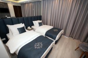 two beds in a hotel room with curtains at Batroun boutique suites in Batroûn