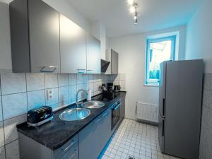 a kitchen with a sink and a refrigerator at Workers Apartment with Balcony in Ratekau