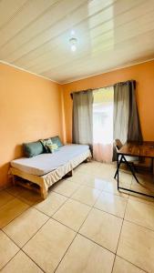 ein Schlafzimmer mit einem Bett und einem Tisch und einem Fenster in der Unterkunft Cozy coworking Casa Alma near Lake Arenal, 2 bedroom 1 office, fiber optic, pet friendly in Nuevo Arenal