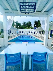 een witte tafel en stoelen voor een zwembad bij Issa's Haven Resort in Look
