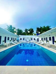 een groot zwembad met blauwe tegels in een gebouw bij Issa's Haven Resort in Look