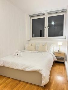 un letto bianco in una stanza con finestra di Apartment in Angel. a Londra