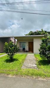 ein kleines weißes Haus mit einer Veranda in der Unterkunft Cozy coworking Casa Alma near Lake Arenal, 2 bedroom 1 office, fiber optic, pet friendly in Nuevo Arenal