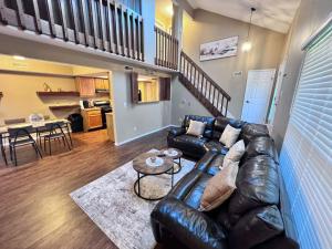 a living room with a leather couch and a table at The Cozy Townhouse WPAFB & WSU in Fairborn