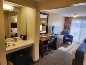 a hotel room with a desk and a bedroom at Hyannis Travel Inn in Hyannis