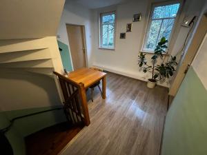 Habitación con mesa de madera y escalera. en Monteurunterkunft Zum Mohr, en Birstein