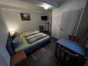 ein kleines Schlafzimmer mit einem Bett und einem Tisch in der Unterkunft Monteurunterkunft Zum Mohr in Birstein