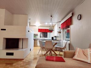 sala de estar con chimenea, mesa y sillas en Tilava asunto saunalla en Kuusamo