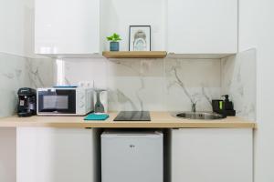 a kitchen counter with a microwave and a sink at NICEHOME MASSENA in Nice