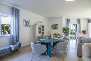 a dining room with a blue table and chairs at Casa Clara in Vilamoura