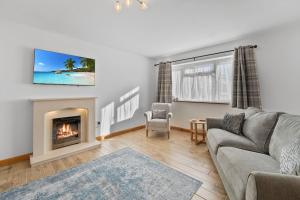 a living room with a couch and a fireplace at Orchard View in Ash