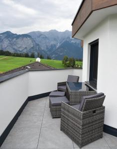 un patio con sedie e tavolo in un edificio di Mountain View Appartements mit Blick NORDKETTENBLICK a Innsbruck