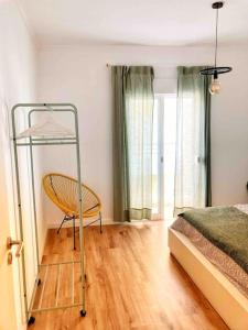 um quarto com uma cama e uma cadeira num quarto em Shiny Apartment in the city center na Fuzeta