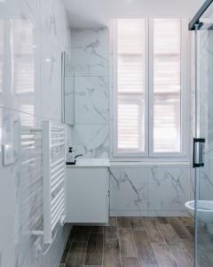 a white bathroom with a sink and a window at Studio Nicehome Massena in Nice +62 photos