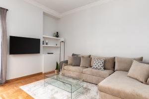 uma sala de estar com um sofá e uma televisão na parede em KASO - Fotomara em Atenas
