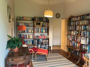 a living room with book shelves filled with books at Aquila Retreats in Comrie