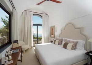 a bedroom with a large bed and a large window at Furore Grand Hotel in Furore