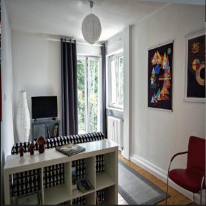 een woonkamer met een tafel en een rode stoel bij Stadt- Naturnah, Traumblick und Balkon in Baden-Baden