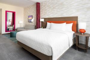 ein Schlafzimmer mit einem großen Bett und ein Wohnzimmer in der Unterkunft Home2 Suites By Hilton Lake Mary Orlando in Lake Mary