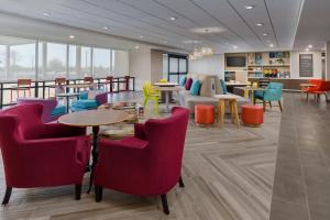 uma sala de espera com cadeiras e mesas num edifício em Home2 Suites By Hilton Lake Mary Orlando em Lake Mary