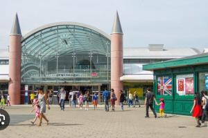 un groupe de personnes marchant devant un bâtiment dans l'établissement De Disney à Paris - Pré Verson 1, à Chessy