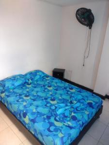 Cama en habitación con edredón azul en Hotel el Manaa Santa Marta en Cúcuta