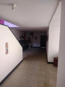 una habitación vacía con un pasillo con paredes blancas en Hotel el Manaa Santa Marta en Cúcuta