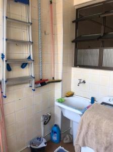 a bathroom with a sink and a bath tub at Quarto e sala Boqueirão quadra da praia in Santos
