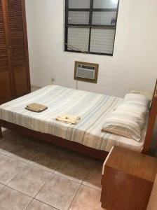 a bed with two towels on it in a bedroom at Quarto e sala Boqueirão quadra da praia in Santos