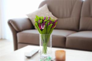 un vase de fleurs sur une table devant un canapé dans l'établissement Wehrbergsdüne 26, FeWo 4, à Duhnen