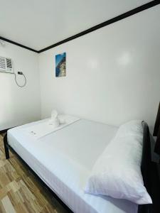 ein großes weißes Bett in einem weißen Zimmer in der Unterkunft 3 Sisters Guest House 2 in Moalboal