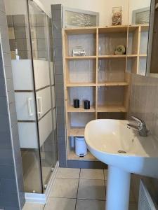 a bathroom with a sink and a glass shower at "LA VAGUE" Maison 6 personnes, terrasse, Port plaisance, garage vélos in Talmont