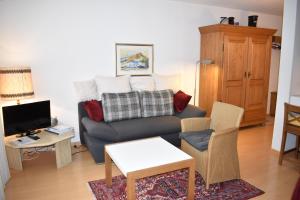 a living room with a couch and a tv at La Riva (159 Br) in Lenzerheide