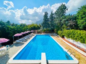 a swimming pool with chairs and umbrellas at Villa Giada in Carini