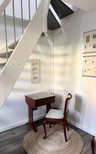 a desk and a chair sitting under a staircase at Ferienwohnung Kamrath Altstadt in Neuruppin +9 photos
