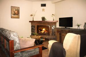 a living room with a fireplace and a tv at Ruralguejar in Güéjar-Sierra