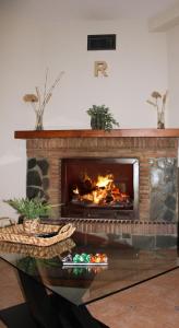 a brick fireplace with a fire in a living room at Ruralguejar in Güéjar-Sierra