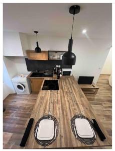 uma cozinha com uma longa mesa de madeira com dois lugares em Appartement chaleureux en hyper centre de Gap em Gap