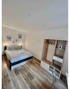 a bedroom with a bed and a wooden floor at Appartement chaleureux en hyper centre de Gap in Gap