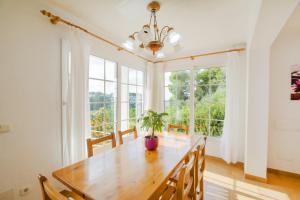 a dining room with a wooden table and a potted plant at Miramar K by Sonne Villas in Cala Galdana