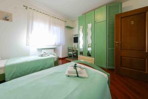 a bedroom with two beds and green cabinets at Chiarelli House in Udine