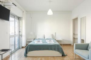 クアルテイラにあるSea Studioの白いベッドルーム(ベッド1台、椅子付)