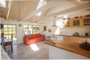 a living room with an orange couch in a kitchen at Kongsholmlund - Silent retreat in Vejby