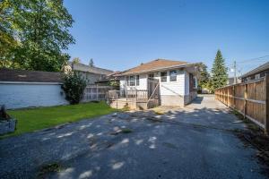 a house with a fence next to a driveway at Fields Inn Executive Townhouse in Kingston