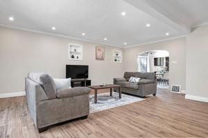 a living room with two chairs and a television at Fields Inn Executive Townhouse in Kingston