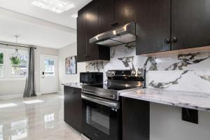 a kitchen with black appliances and marble counter tops at Fields Inn Executive Townhouse in Kingston