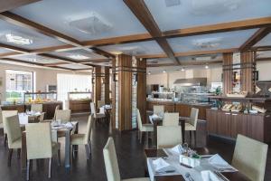 restauracja ze stołami i krzesłami oraz kuchnią w obiekcie Апартамент Б306 в Обзор Бийч Резорт на първа линия с перфектен изглед към плажа! w Obzorze